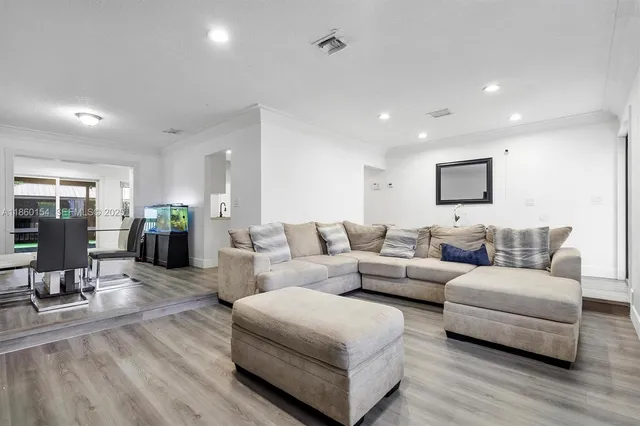 a living room with furniture and wooden floor
