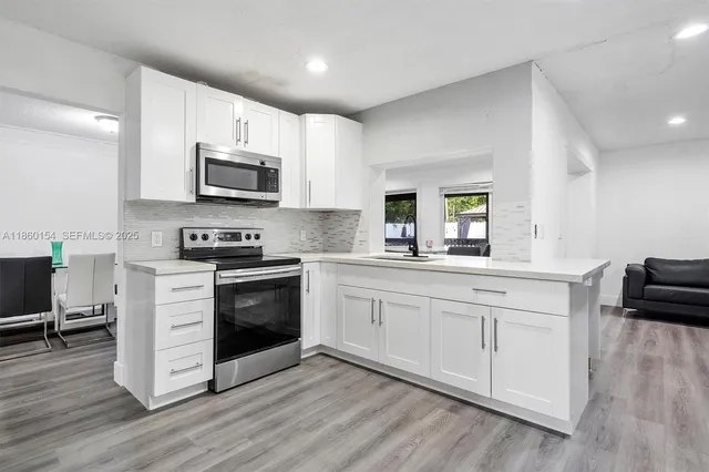 a kitchen with granite countertop white cabinets and appliances