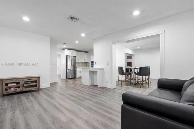 a living room with furniture and a wooden floor
