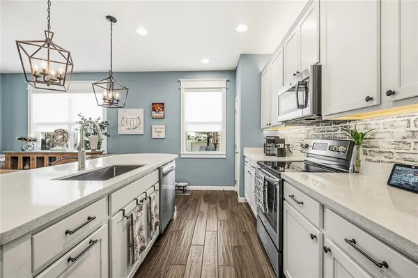 a kitchen with stainless steel appliances granite countertop a sink and stove