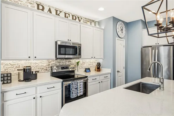 a kitchen with stainless steel appliances a stove a sink a refrigerator and cabinets