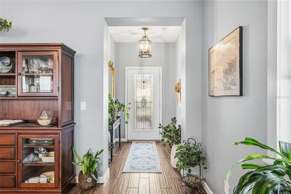 a view of a hallway with wooden floor and a large mirror