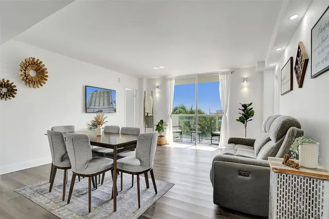 a living room with furniture a wooden floor and a potted plant