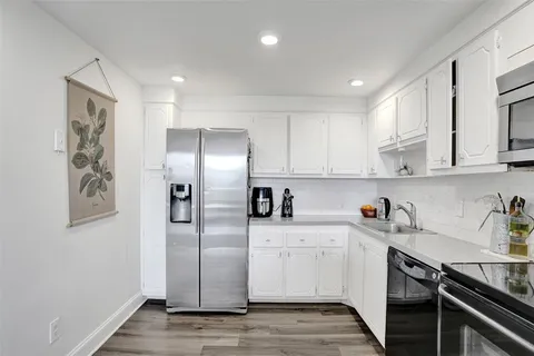 a kitchen with a sink stainless steel appliances and cabinets
