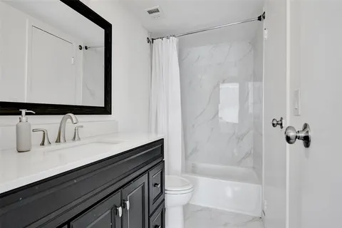 a bathroom with a sink a toilet a mirror and shower