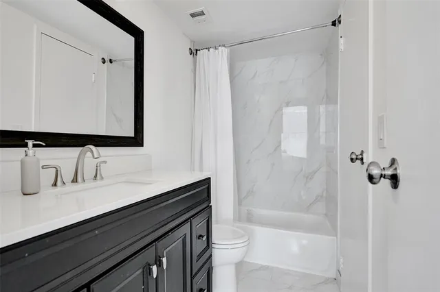 a bathroom with a sink a toilet a mirror and shower