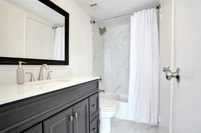 a bathroom with a granite countertop sink toilet a large mirror and shower