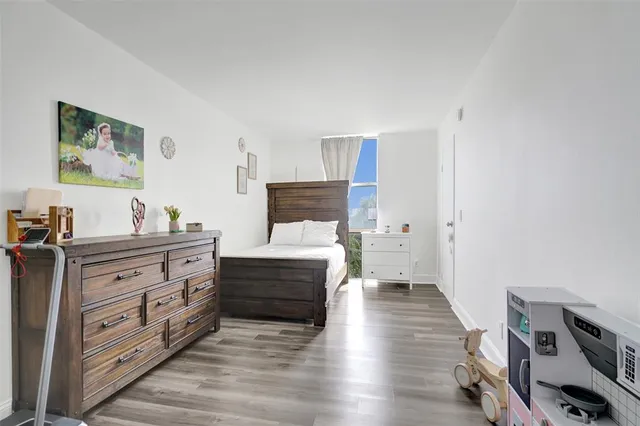 a bedroom with a bed and wooden floor