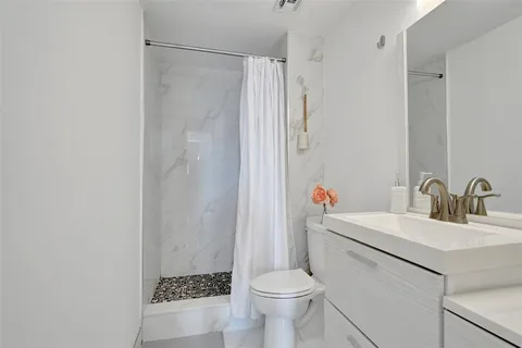 a bathroom with a sink toilet and shower