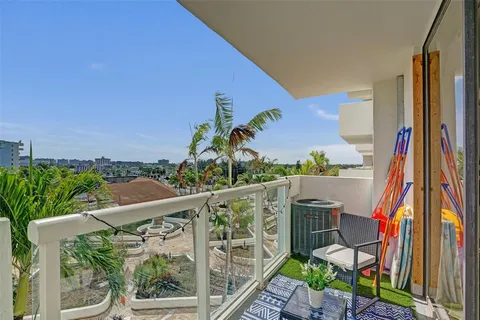 a balcony with wooden floor and outdoor seating