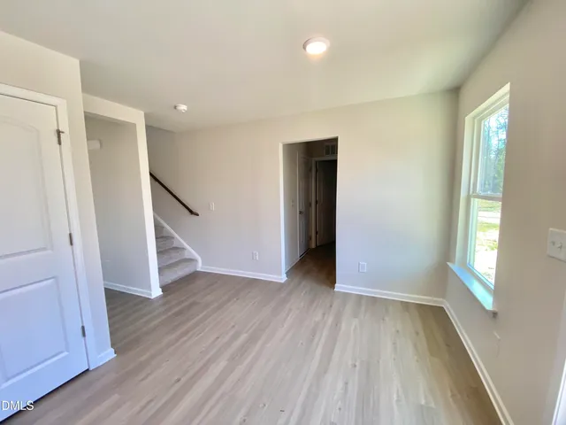 an empty room with a window and a ceiling fan