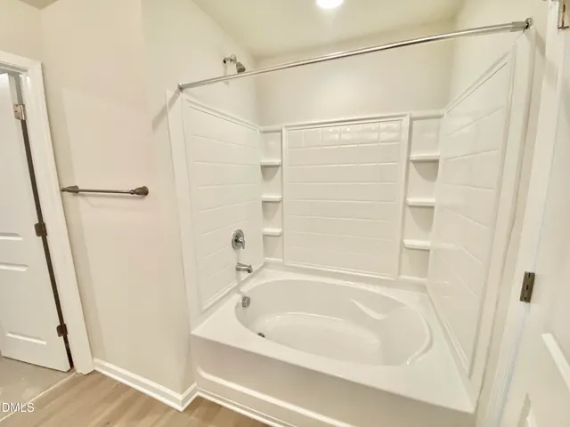a white bath tub sitting next to a white toilet and sink