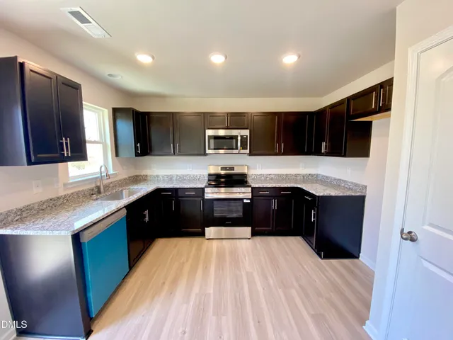 a kitchen with granite countertop stainless steel appliances and sink