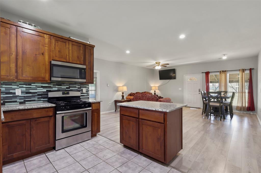 1556 John Wayne Road Kaufman, TX 75142 - Photo 8 of 33 a kitchen with a stove top oven and cabinets