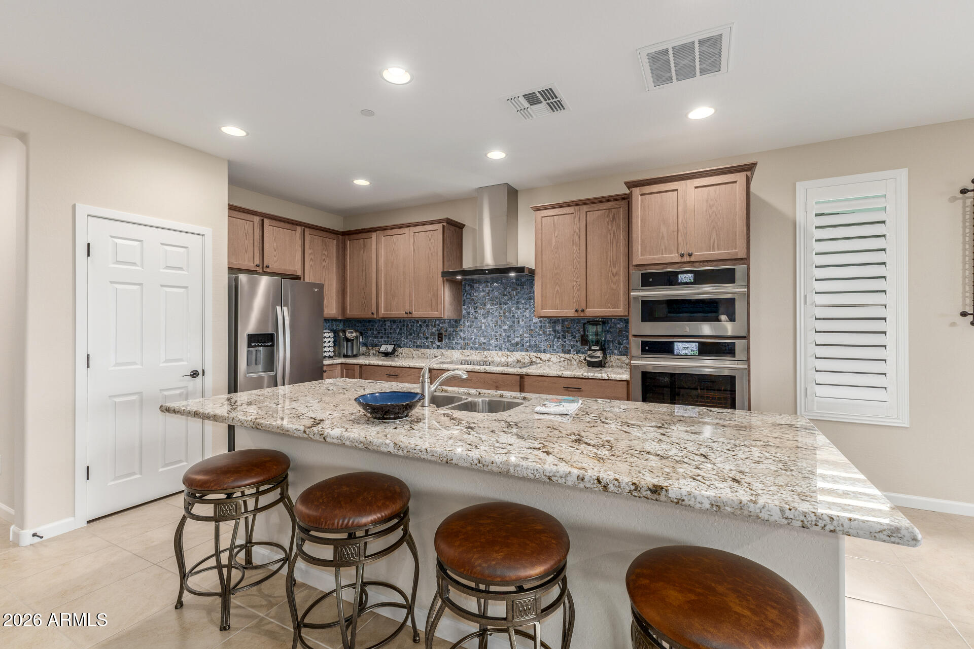 18325 East Spring Valley Court Rio Verde, AZ 85263 - Photo 13 of 50 a kitchen with kitchen island granite countertop wooden cabinets and stainless steel appliances