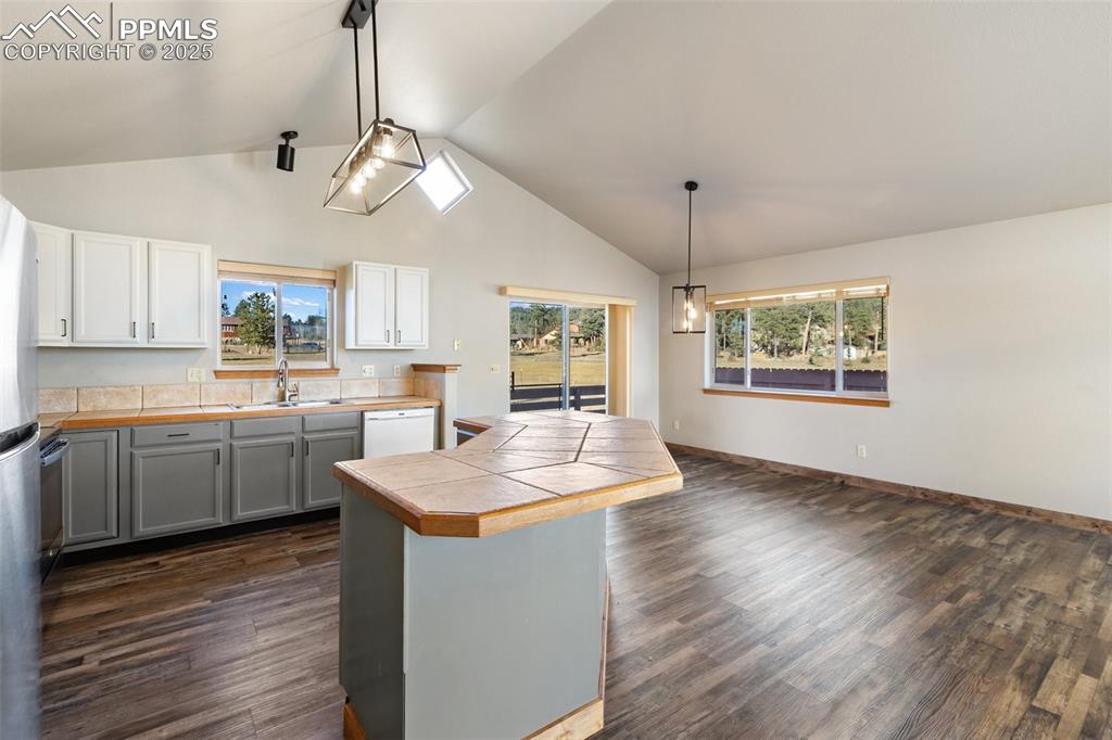 1380 Rampart Range Road Woodland Park, CO 80863 - Photo 7 of 30 a kitchen with kitchen island white cabinets and wooden floor