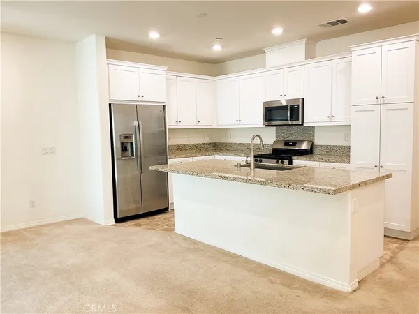 a view of a kitchen with a sink and a refrigerator