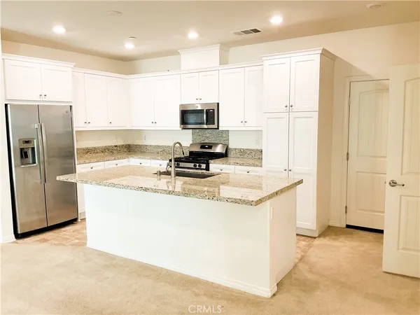 a kitchen with granite countertop a sink stainless steel appliances and cabinets