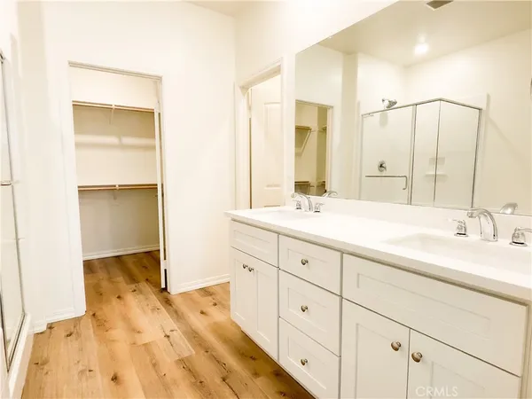 a bathroom with a double vanity sink a mirror and a bathtub