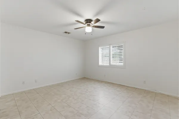 an empty room with a window and a fan
