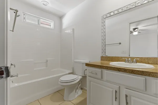 a bathroom with a granite countertop sink a toilet and a bathtub