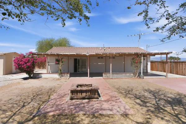a front view of a house with a yard and seating space