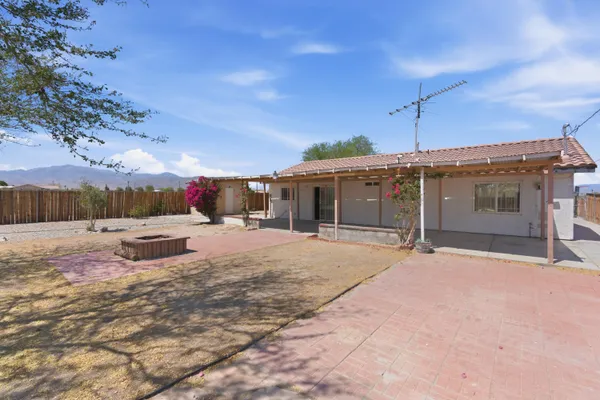 a swimming pool with yard and a wooden fence