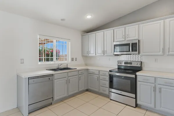 a kitchen with white cabinets stainless steel appliances and a sink
