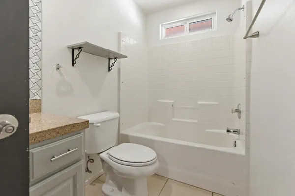a bathroom with a granite countertop toilet a sink and bathtub
