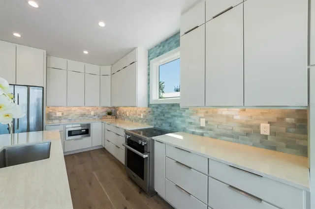 a kitchen with a table chairs refrigerator and microwave