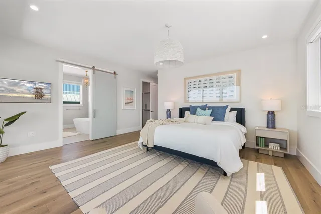 a large bedroom with a large bed and a view of living room