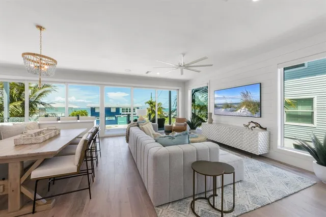 a living room with furniture ceiling fan and a large window