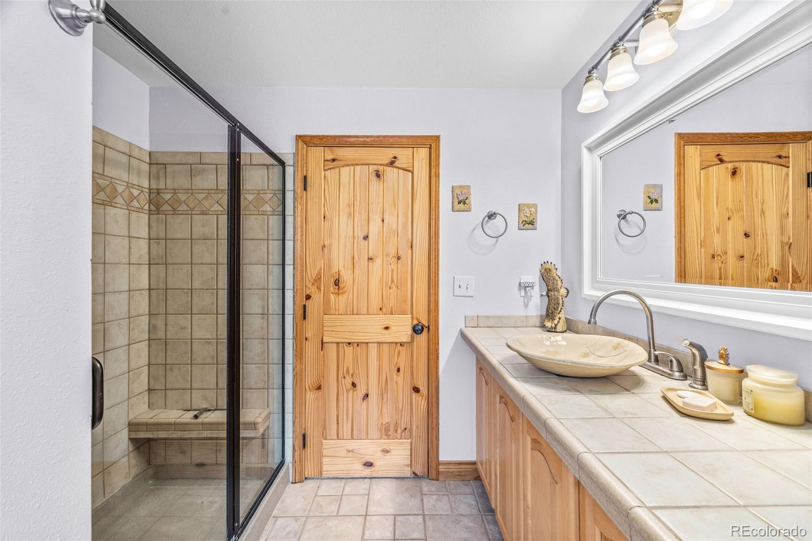 2020 Mullenville Road Fairplay, CO 80440 - Photo 31 of 49 a bathroom with a granite countertop sink a toilet and shower