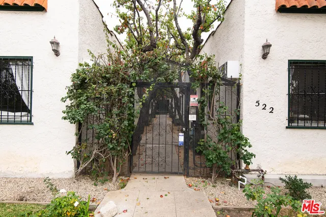 a view of a entrance gate of the house and trees