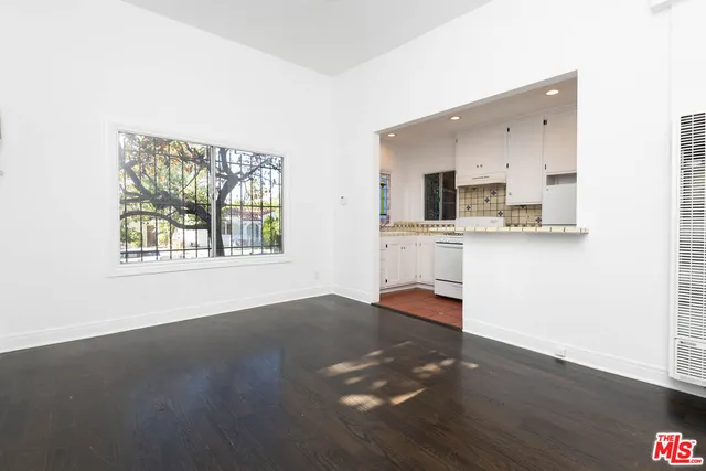 a view of a kitchen with wooden floor and a window