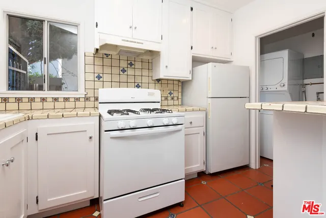 a kitchen with white cabinets and white appliances