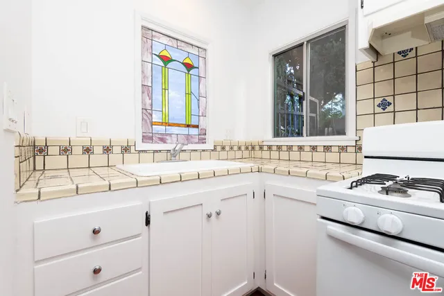 a kitchen with granite countertop white cabinets and white appliances