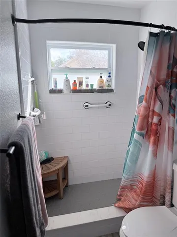 a white toilet sitting next to a shower curtain