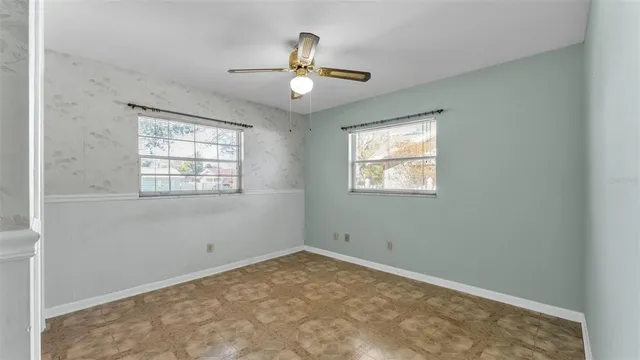 an empty room with windows and fan