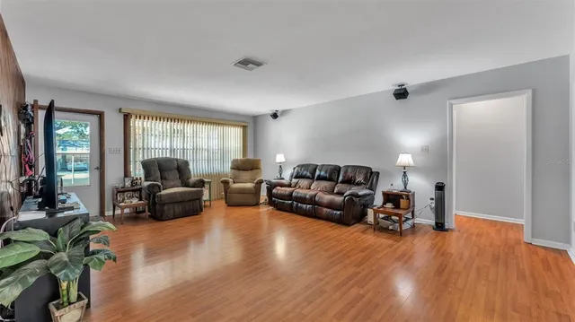 a living room with furniture and a flat screen tv with wooden floor