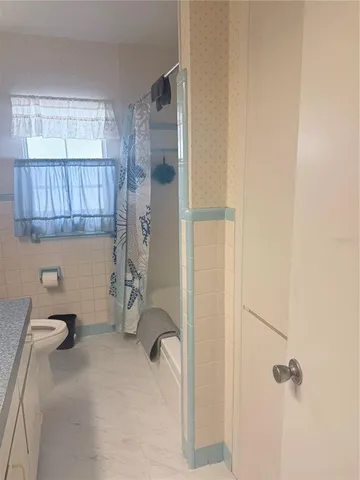 a bathroom with a granite countertop sink a toilet and bathtub