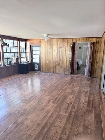 a view of walk in closet with window and hardwood floor
