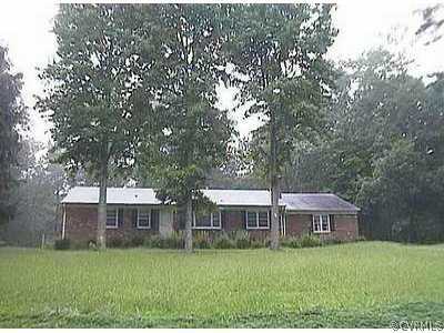 a view of a big house with a big yard and large trees