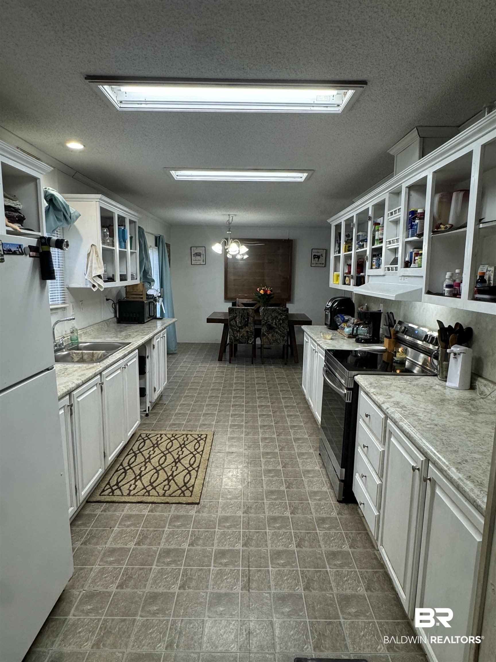 51235 Phillipsville Road Bay Minette, AL 36507 - Photo 31 of 63 Kitchen featuring open shelves, white cabinetry, stainless steel electric stove, light countertops, and freestanding refrigerator