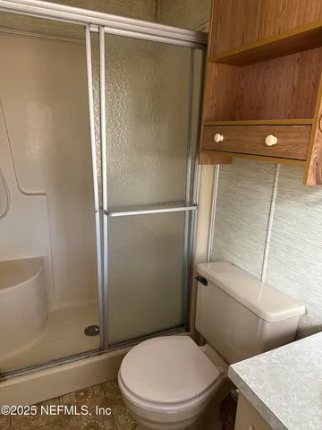 a white toilet sitting next to a bath tub