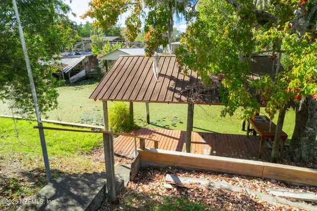 a view of a yard with chairs and table in the patio