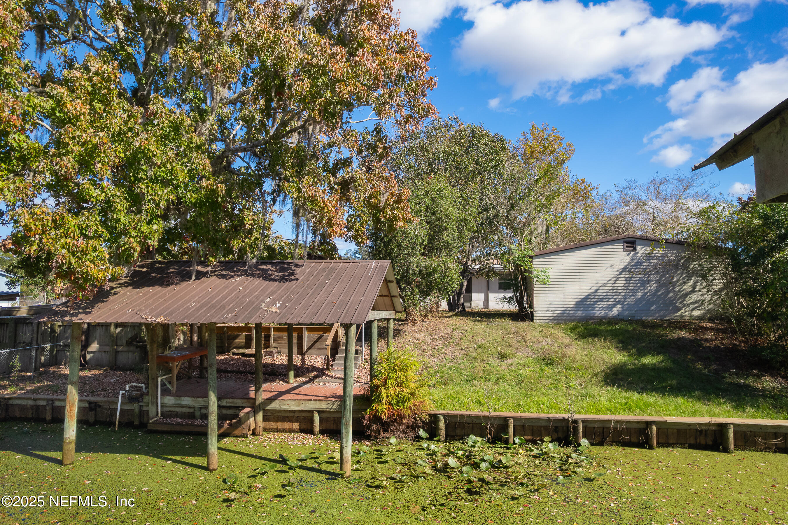 125 Waterside Avenue Satsuma, FL 32189 - Photo 28 of 32 a view of a patio with table and chairs under an umbrella