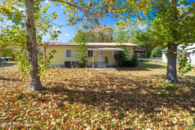 a view of a house with a tree in the yard
