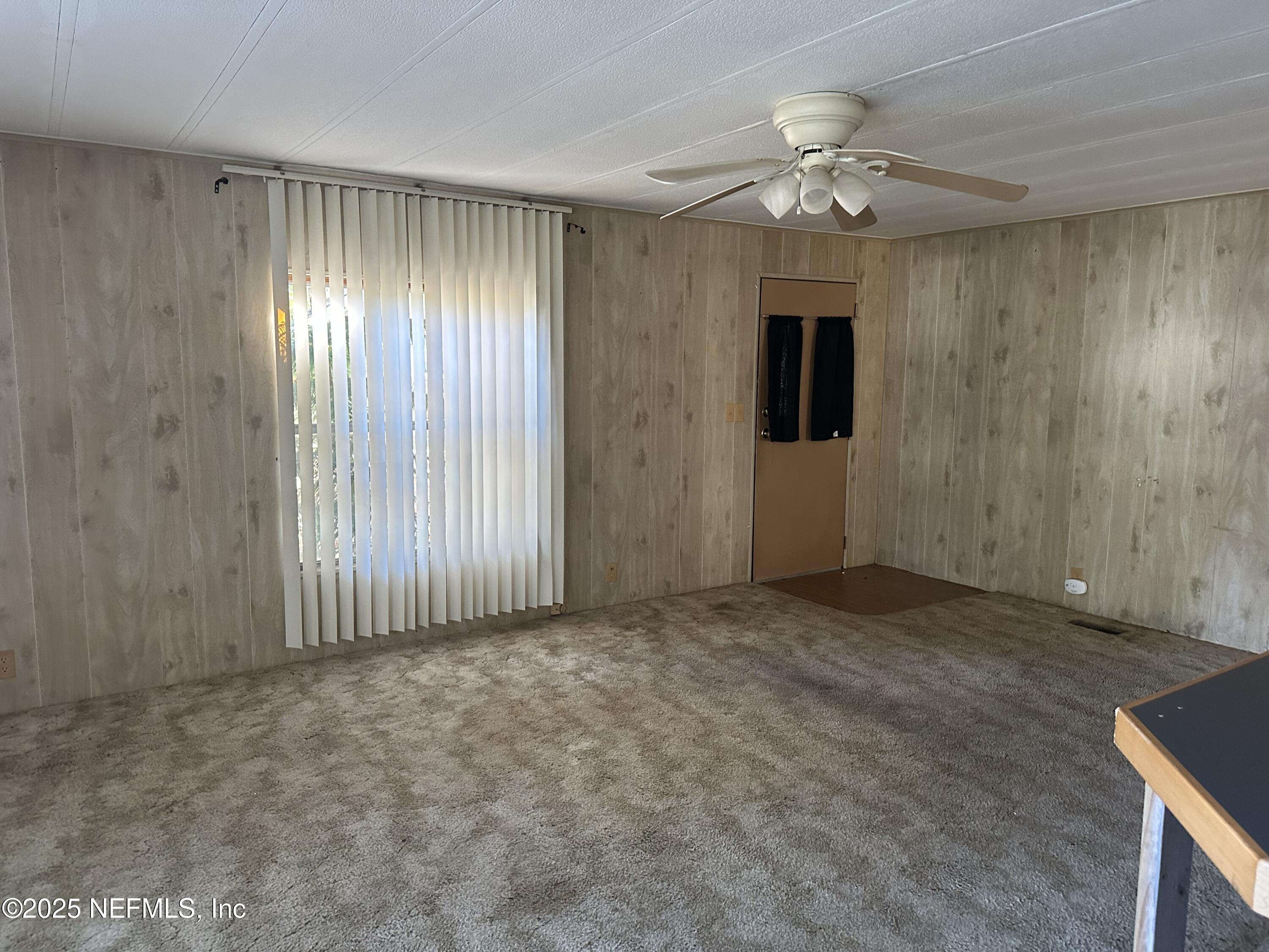 125 Waterside Avenue Satsuma, FL 32189 - Photo 6 of 32 an empty room with chandelier fan and windows