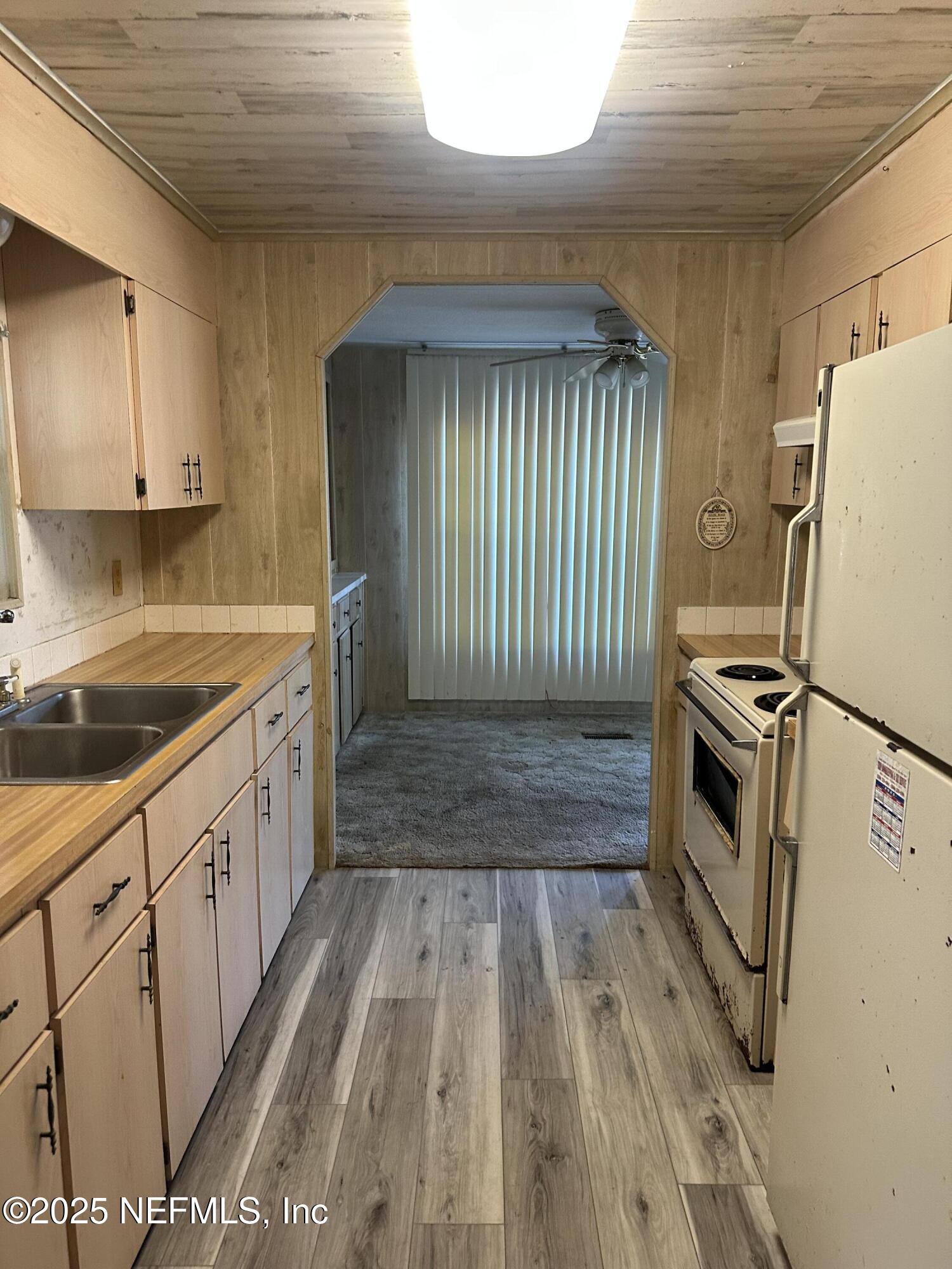 125 Waterside Avenue Satsuma, FL 32189 - Photo 9 of 32 a kitchen with a sink a refrigerator and cabinets